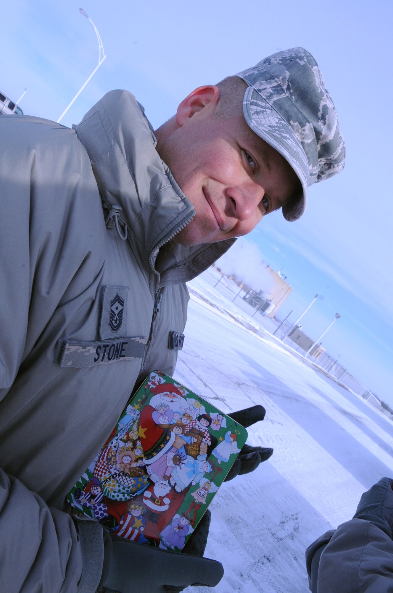 Senior Master Sgt. Brian Stone, 69th Reconnaissance Group first sergeant, poses with a tin of cookies he delivered to Airmen Dec. 10, 2012, at Cavalier Air Station, N.D. Every year, the Grand Forks Air Force Base Spouses’ Club shows their appreciation to Airmen on base by baking cookies and assembling cookie bags to surprise Airmen who live in the dorms.  This year, the Grand Forks AFB First Sergeants’ Council delivered cookies to Airmen stationed on Cavalier Air Station and Grand Forks AFB, N.D. (U.S. Air Force photo/Staff Sgt. Amanda N. Grabiec)