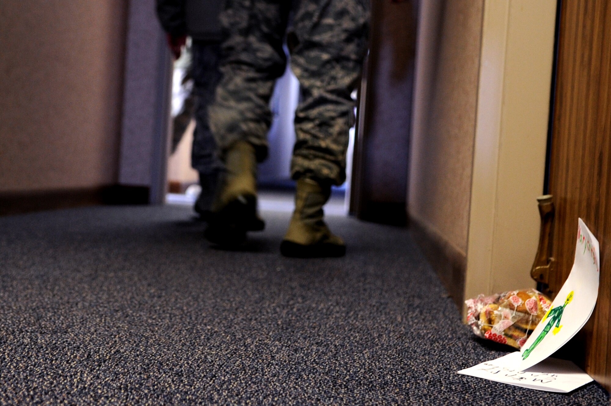 The Grand Forks Air Force Base First Sergeants’ Council sets down a bag of cookies and a few homemade holiday cards at the doorway of an Airman’s dorm room at Cavalier Air Station, N.D., Dec. 10, 2012. Every year, the Grand Forks Air Force Base Spouses’ Club shows their appreciation to Airmen on base by baking cookies and assembling cookie bags to surprise Airmen who live in the dorms.  This year, the First Sergeants’ Council delivered cookies to Airmen stationed on Cavalier Air Station and Grand Forks AFB, N.D. (U.S. Air Force photo/Staff Sgt. Amanda N. Grabiec)
