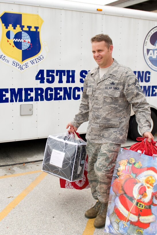 Senior Master Sgt. Galen Zalace, 45th Space Wing Civil Engineer Squadron,
carries toys to be transferred by the Brevard Family Partnership to children
in the local community that are in foster care or abuse prevention programs at the Prime Base Engineer Emergency Force building Dec. 10.
