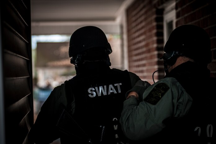 Two Charleston County Sheriff’s Office Special Weapons and Tactics members take cover behind a wall during a hostage extraction training exercise Dec. 6, 2012, at vacant housing on Joint Base Charleston – Air Base, S.C.  The SWAT team provides a coordinated response to critical incidents throughout Charleston County, and whenever requested, in other areas throughout the state of South Carolina. (U.S. Air Force photo/ Senior Airman Dennis Sloan)