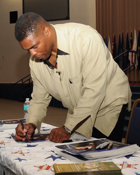 Herschel Walker, Heisman Trophy winner, signs an autograph for a fan during his visit to Barksdale Air Force Base, La., Dec. 11. During his visit, Walker spoke with Airmen about his career, signed autographs and posed for pictures and received a tour of a B-52H Stratofortress static display. (U.S. Air Force photo/Senior Airman Sean Martin)