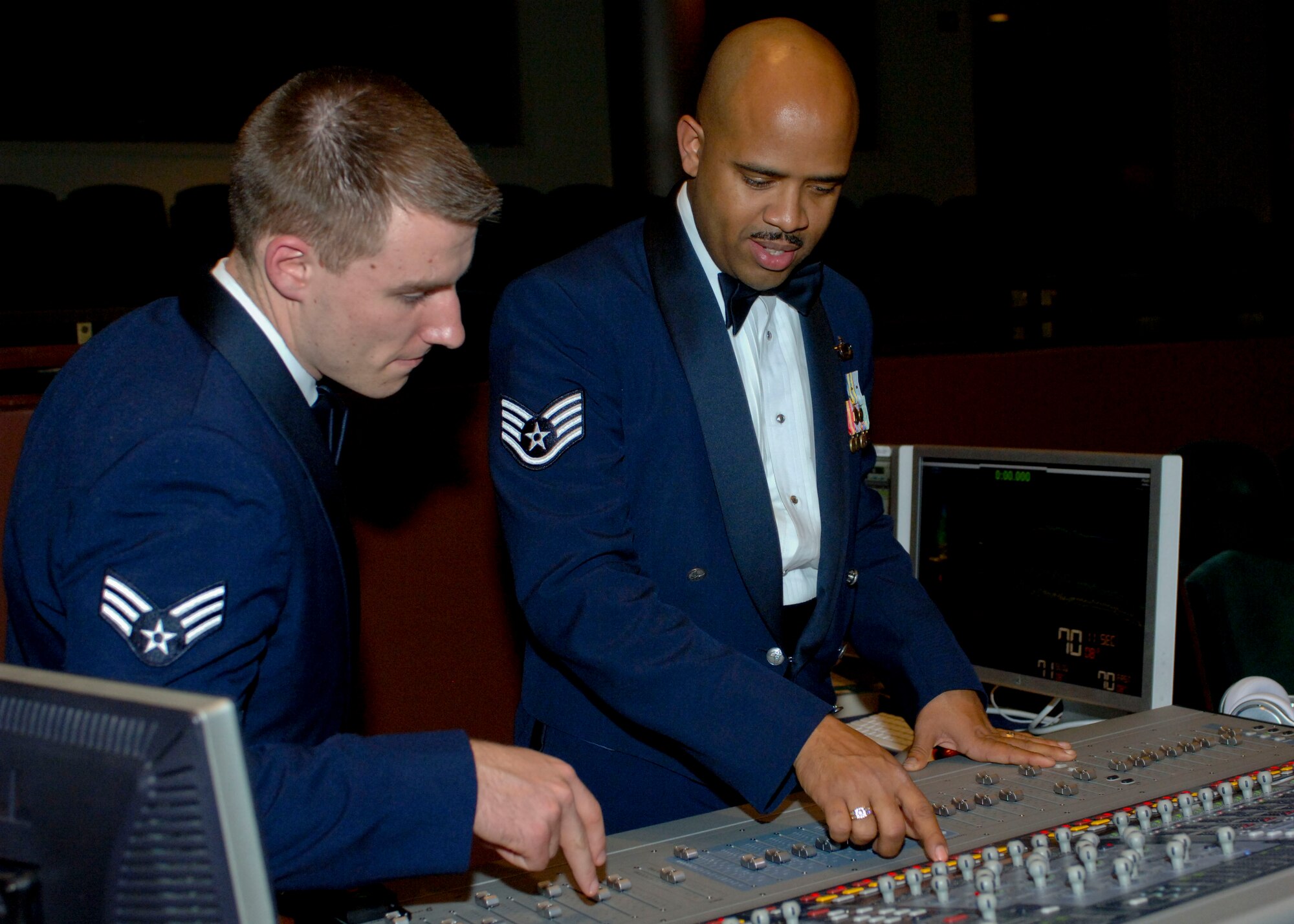 Staff Sgt. Kelcey McDonald, U.S. Air Force Heritage of America Band audio engineer, mentors Senior Airman William Anger, a recent re-trainee to the band, Dec. 7, 2012, at Christopher Newport University’s Ferguson Hall, Newport News, Va. McDonald graduated from Hampton University in Hampton, Va. with a degree in musical engineering technology and a performance arts degree in percussion. (U.S. Air Force photo by Airman 1st Class R. Alex Durbin/Released)