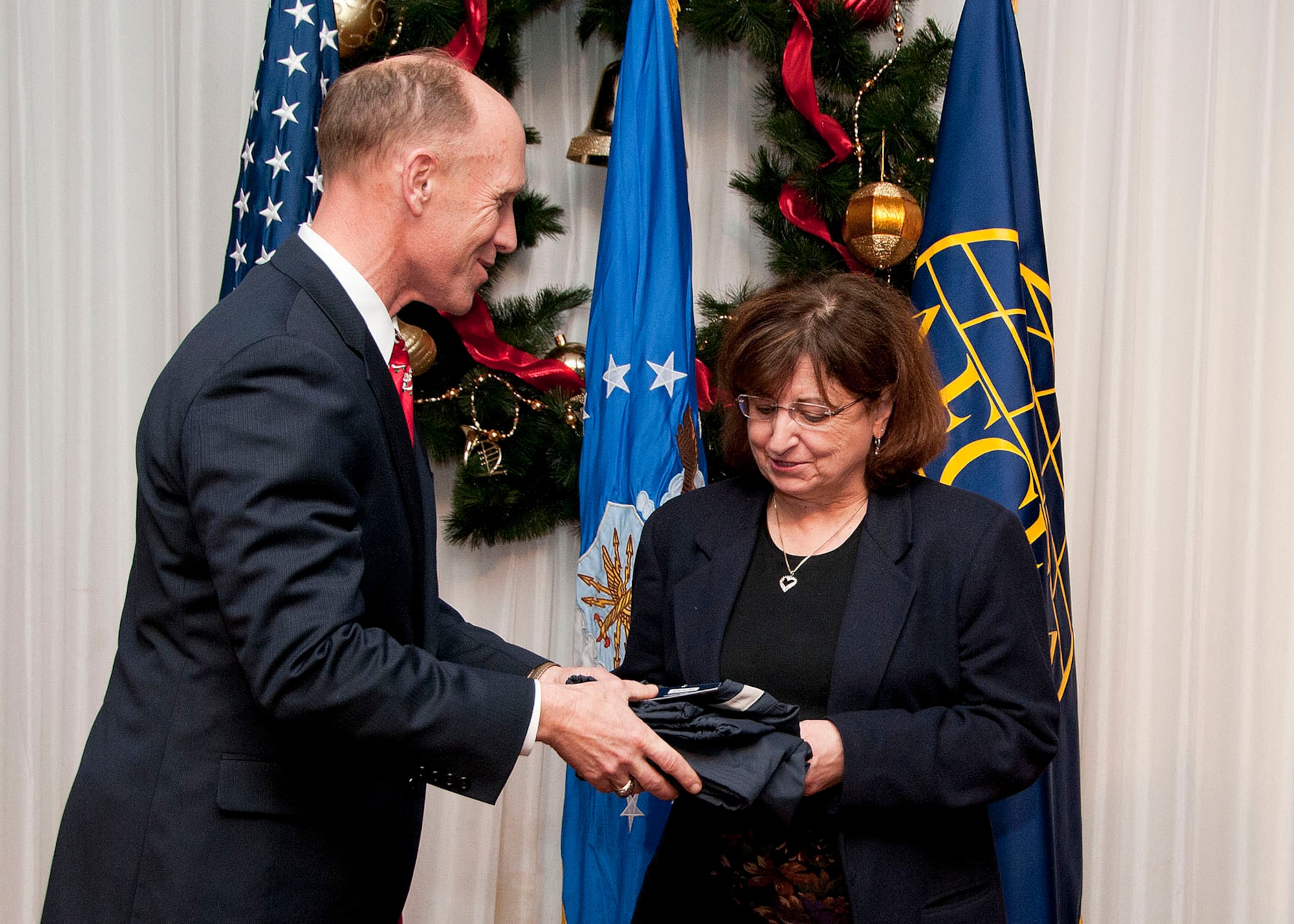 HANSCOM AIR FORCE BASE, Mass. -- Donald Vazquez, Armed Forces Communications and Electronics Association Lexington-Concord chapter 1st vice president, presents Donna Bibeau with the AFCEA Unsung Hero Award at the Minuteman Commons Dec. 5. Program Executive Offices, the 66th Air Base Group and Contracting each selected a hero who made outstanding contributions to their respective organization, Air Force Life Cycle Management Center and the Air Force in 2012. (U.S. Air Force photo by Mark Wyatt)