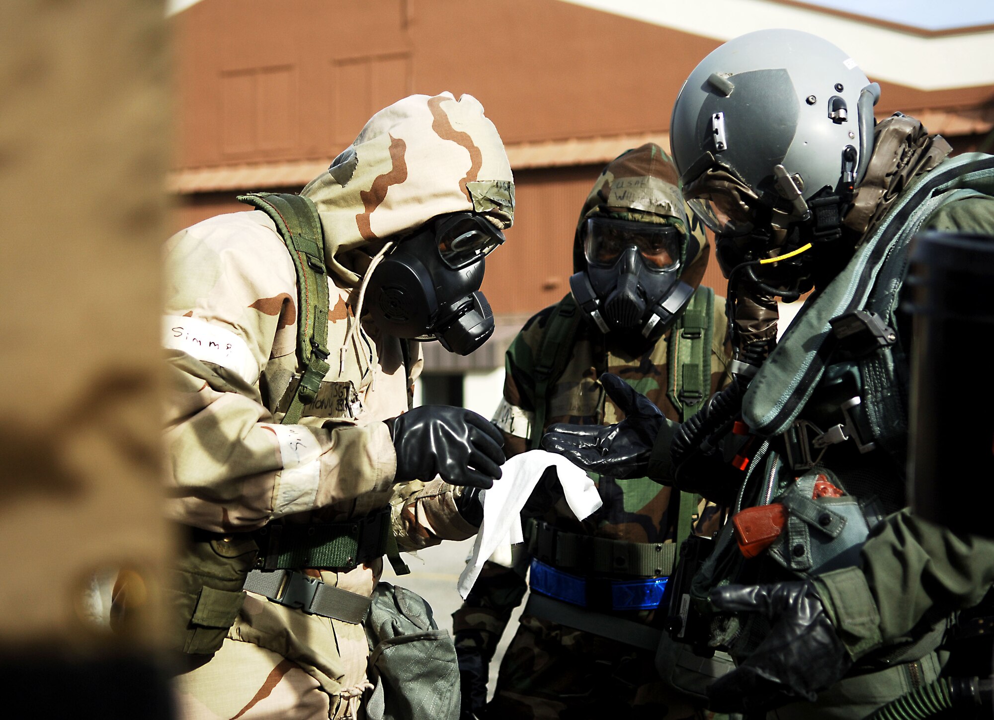 Aircrew flight equipment technicians with the 1st Operations Support Squadron conduct a pilot de-contamination exercise at Langley Air Force Base, Va., Dec. 7, 2012.  In addition to inspecting the aircrew equipment for safety, AFE technicians also de-contaminate aircrew in the event of contamination.  (U.S. Air Force photo by Staff Sgt. Katie Gar Ward / Released)