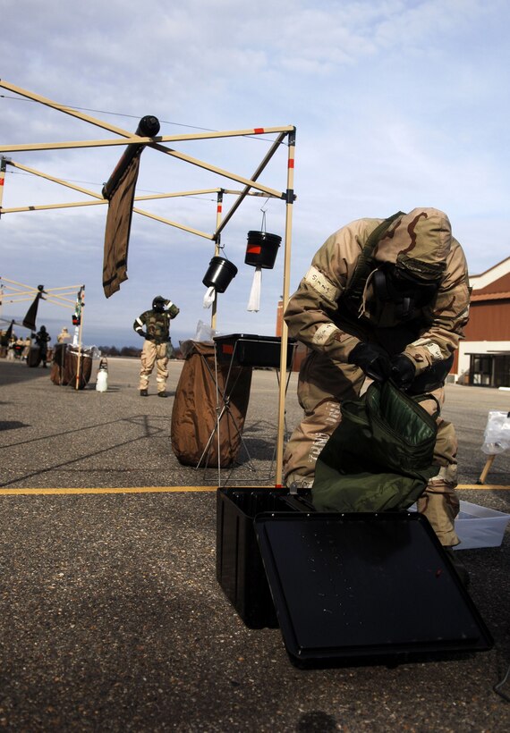 Aircrew flight equipment technicians with the 1st Operations Support Squadron prepare for a pilot decontamination exercise at Langley Air Force Base, Va., Dec. 7, 2012.  The aircrew de-contamination process consists of four zones that include seven various de-contamination stations. (U.S. Air Force photo by Staff Sgt. Katie Gar Ward / Released)