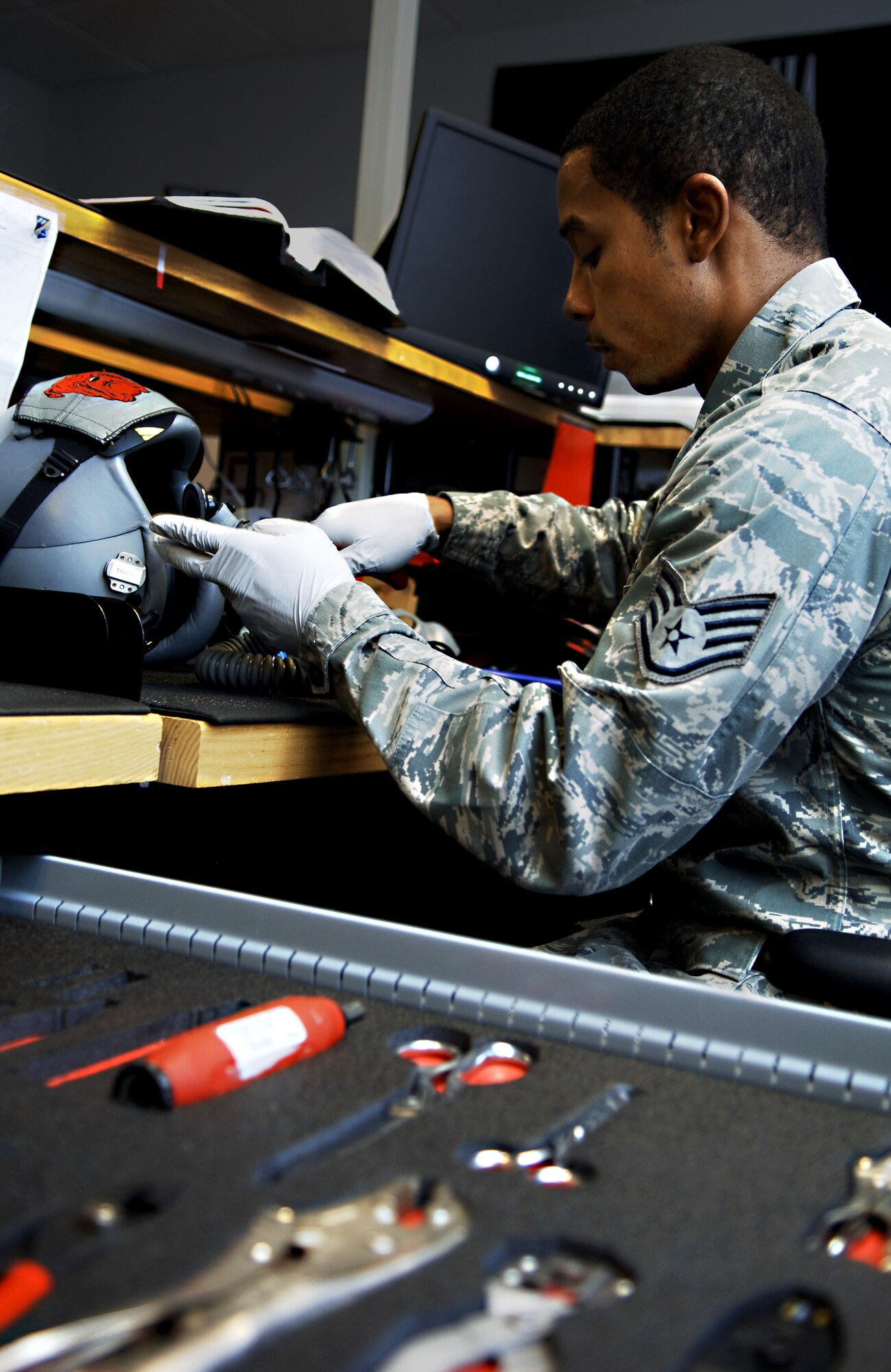 Staff Sgt. Chester Boothe, floor chief with the 27th Aircrew Flight Equipment T-38 section, inspects a pilot’s helmet at Langley Air Force Base, Va., Dec. 3, 2012.   Booth said he feels packing parachutes as an aircrew flight equipment technician is his favorite part of the job, because it’s a direct contribution to saving pilots’ lives.  (U.S. Air Force photo by Staff Sgt. Katie Gar Ward / Released)   