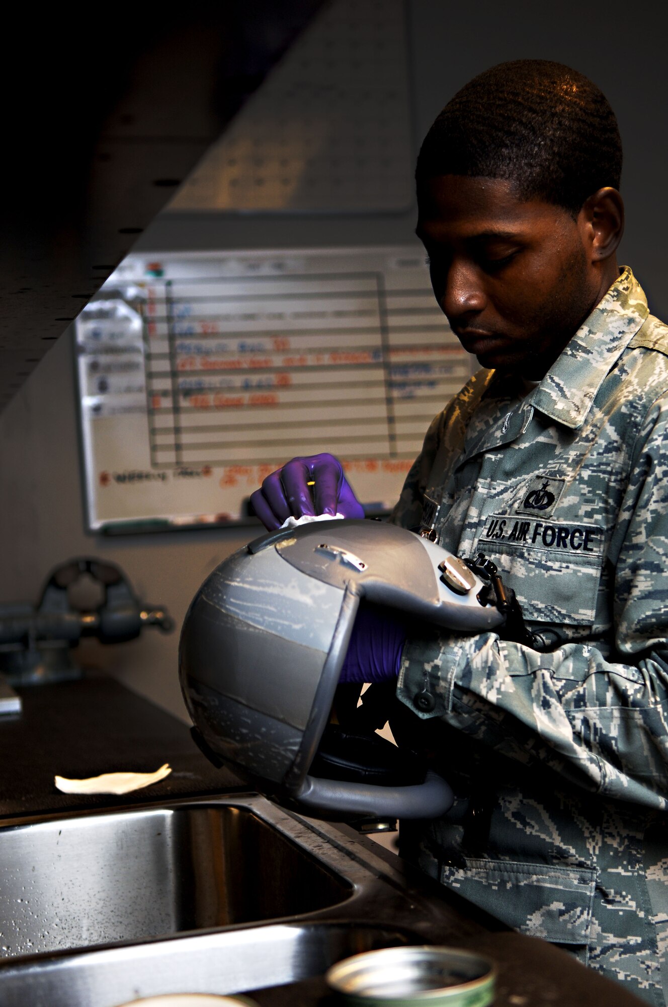 Staff Sgt. Lloyd Williamson, floor chief with the 94th Aircrew Flight Equipment section, cleans and inspects a pilot’s helmet at Langley Air Force Base, Va., Dec. 3, 2012.  The pilot’s helmet, along with a parachute and survival kit, are considered lifesaving flight equipment.  (U.S. Air Force photo by Staff Sgt. Katie Gar Ward / Released)  