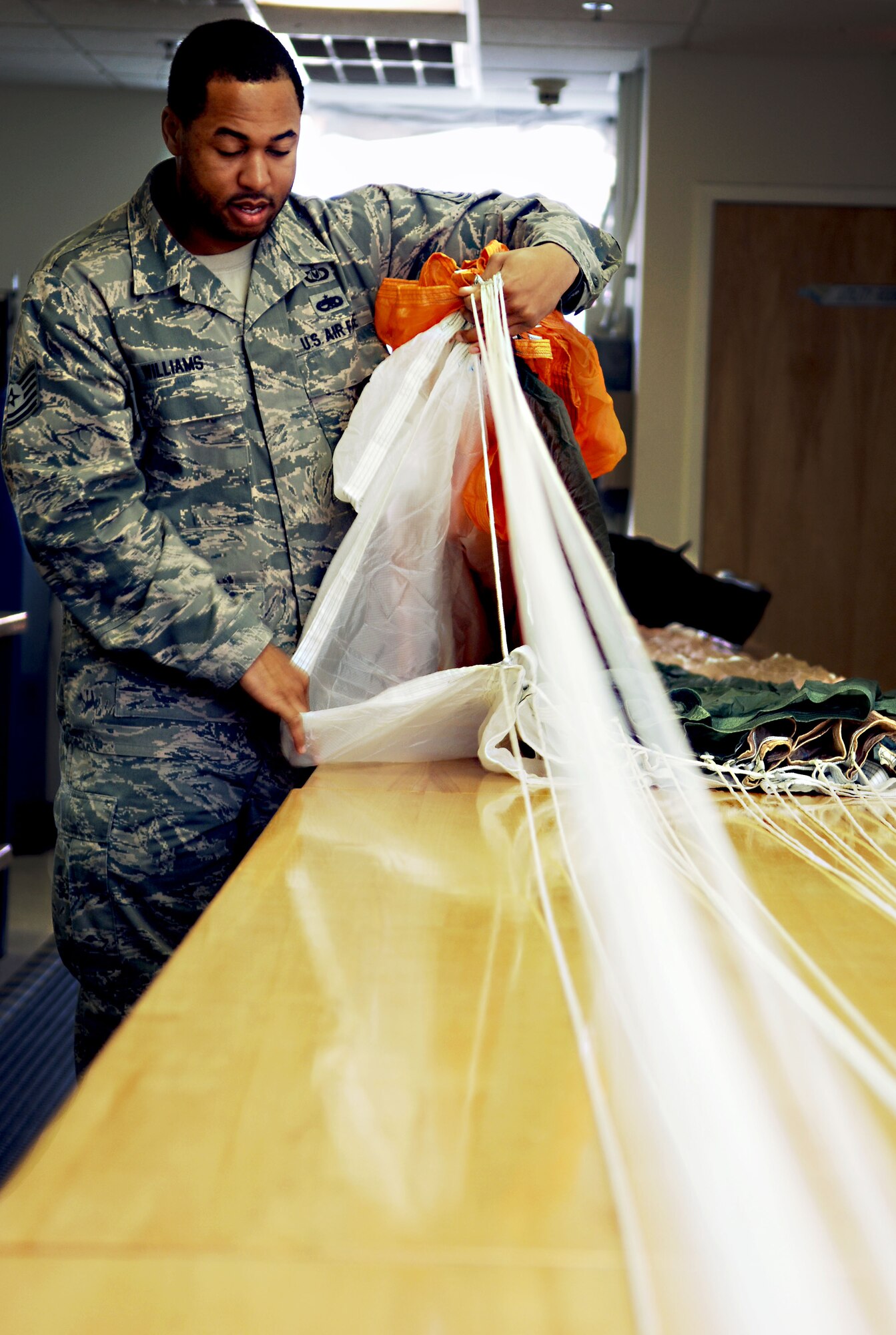 Tech. Sgt. Ralph Williams, aircrew flight equipment craftsman with the 1st Operations Support Squadron, performs a continuity check on an Aces II parachute at Langley Air Force Base, Va., Dec. 3, 2012.  Williams has been an aircrew flight equipment technician for more than 12 years. (U.S. Air Force photo by Staff Sgt. Katie Gar Ward / Released)  