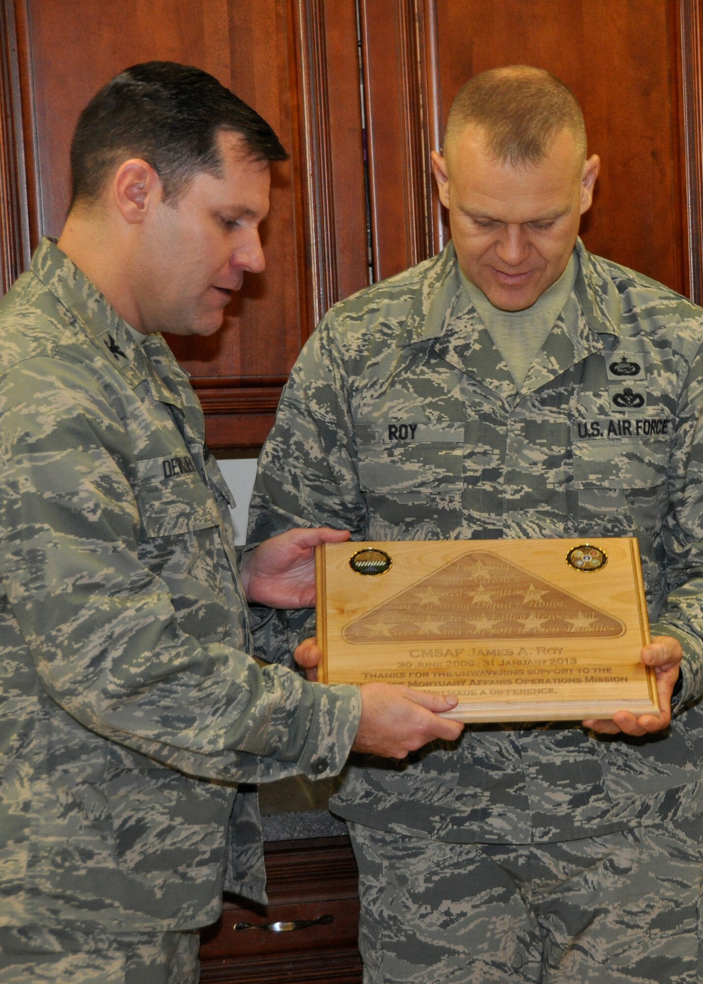 Col. John M. Devillier, Air Force Mortuary Affairs Operations commander, presents Chief Master Sgt. of the Air Force James A. Roy with a plaque for his service as the 16th Chief Master Sergeant of the Air Force. Roy traveled to Dover Air Force Base, Del., to visit the mortuary Dec. 12, 2012 as part of his farewell tour. (U.S. Air Force photo/Master Sgt. Cherie McNeill)