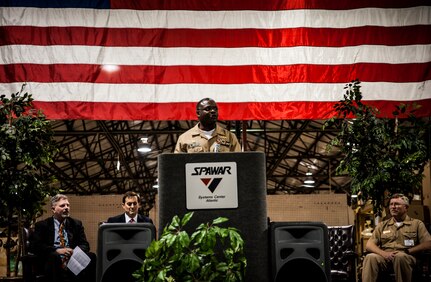 Navy Capt. Mark Glover, Space and Naval Warfare Systems Center Atlantic commanding officer, welcomes attendees to a ceremony held to commemorate the rapid acquisition, integration of electronics and delivery of more than 27,000 MRAP vehicles sent to Iraq and Afghanistan, Dec. 10, 2012, from the SPAWAR integration facility on Joint Base Charleston – Weapons Station, S.C. The team at SPAWAR initially integrated five vehicles a day, but when demand for the vehicles rose, the team stepped production up to integrating 50 vehicles a day. The team even reached the lofty goal of integrating 75 MRAPSs in one day. (U.S. Air Force photo/ Senior Airman Dennis Sloan)