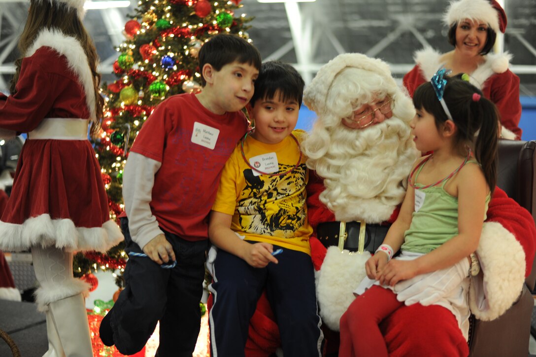 Matthew, 13, and twins Brendon and AnnaLisa, 7, children of Retired Col. Mary Purdue, tell Santa Claus their Christmas wishes during the 25th Annual Parents and Children Fighting Cancer Christmas Party, Dec. 8, 2012 in Hangar 3 on Joint Base Andrews, Md. The annual PCFC event allows military families whose lives have been affected by cancer to come together and enjoy a free holiday celebration with food, performances and displays. (U.S. Air Force photo/Senior Airman Bahja J. Jones)