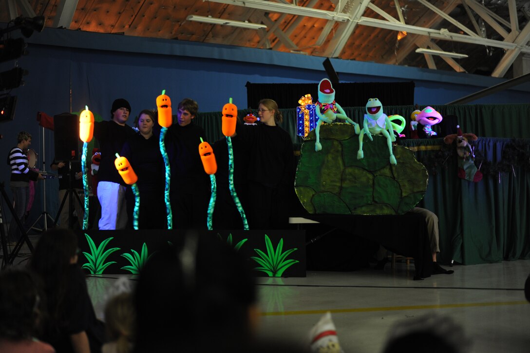 The Berryville Baptist Rascals, Berryville, Va., perform a Christmas carol melody puppet show during the 25th Annual Parents and Children Fighting Cancer Christmas Party, Dec. 8, 2012 in Hangar 3 on Joint Base Andrews,Md. The annual PCFC event allows military families whose lives have been affected by cancer to come together and enjoy a free Christmas celebration with food, performances, displays and special visit from Mr. and Mrs. Santa Claus. (U.S. Air Force photo/Senior Airman Bahja J. Jones) 