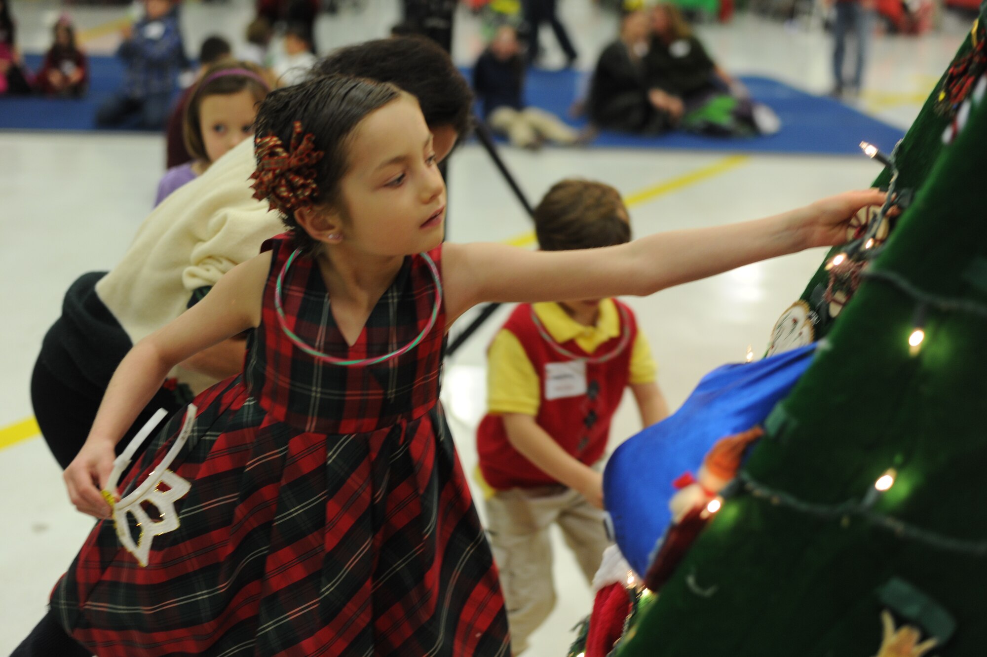 Ali, 9, daughter of Navy Cryptologic Technician Maintenance 1st class Leslie Trotta, Defense Intelligence Agency, Joint Base Anacostia-Bolling, places a decoration on a Christmas tree during the 25th Annual Parents and Children Fighting Cancer Christmas Party, Dec. 8, 2012 in Hangar 3 on Joint Base Andrews, Md. The annual PCFC event allows military families whose lives have been affected by cancer to come together and enjoy a free holiday celebration with food, performances, displays and special visit from Mr. and Mrs. Santa Claus. (U.S. Air Force photo/Senior Airman Bahja J. Jones) 