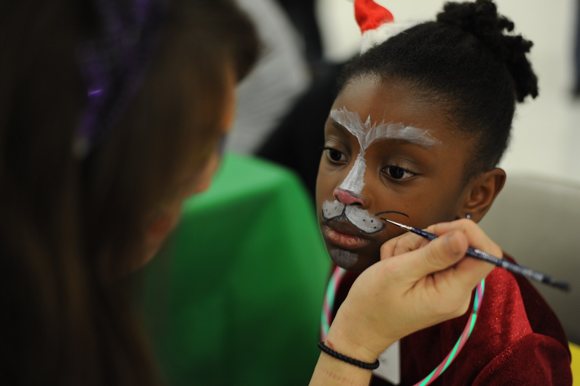 Gabby Balmer, 6, daughter of Master Sgt. Chris Sweet, 11th Force Support Squadron Military Family Support Center NCO in charge, gets her face painted during the 25th Annual Parents Children Fighting Cancer Christmas Party, Dec. 8, 2012 in Hangar 3 on Joint Base Andrews, Md. The annual PCFC event  allows military families whose lives have been affected by cancer to come together and enjoy a free holiday celebration with food, performances, displays and special visit from Mr. and Mrs. Santa Claus. (U.S. Air Force photo/Senior Airman Bahja J. Jones)