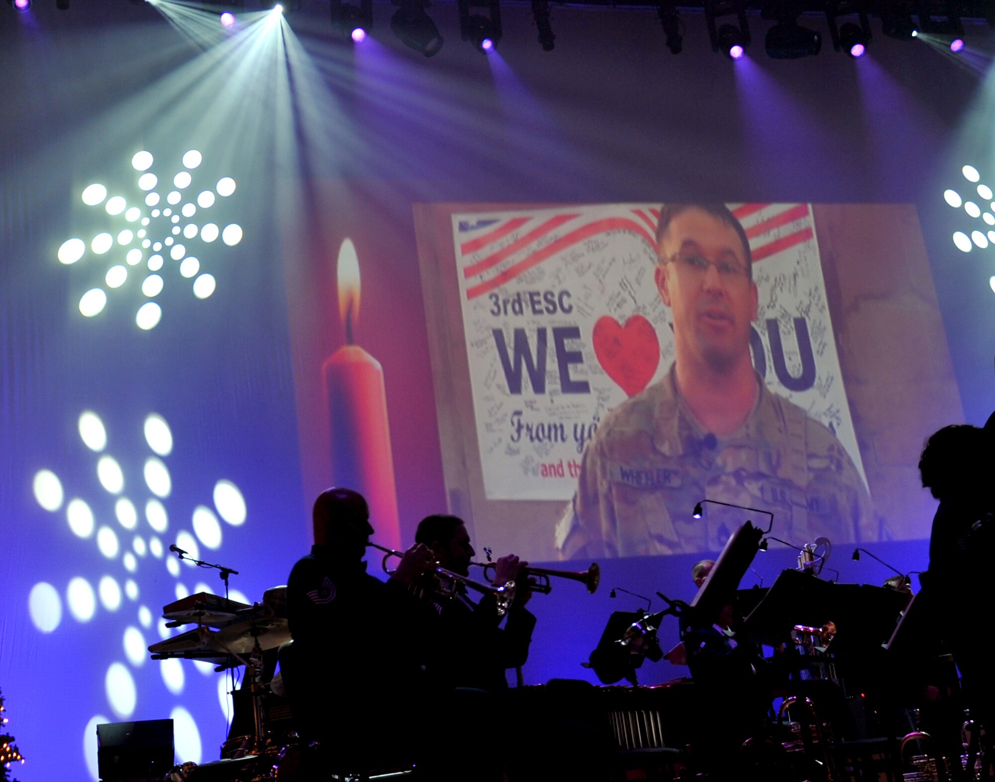 The U.S. Air Force Heartland of America Band performed various holiday favorites at the Holland Performing Arts Center in Omaha, Neb., Dec. 7. As the band played Sgt 1st Class Wheeler, deployed in Kandahar, Afghanistan, sends a video message to his family in Gary, Neb. (U.S. Air Force photo by Jeff W. Gates/Released)