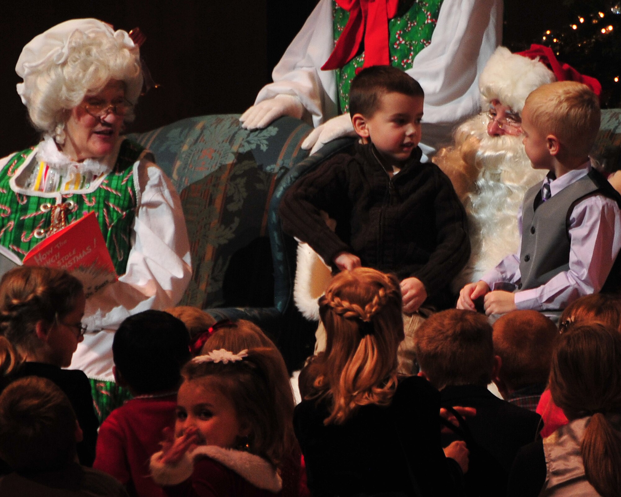 Mrs. Claus reads a story to children as they sit with her and Santa during the annual holiday concert at the Holland Center in Omaha, Neb., Dec. 9. The concert is sponsored by the Omaha World-Herald and is presented each year during the holiday season. (U.S. Air Force photo by Dana P. Heard/Released)