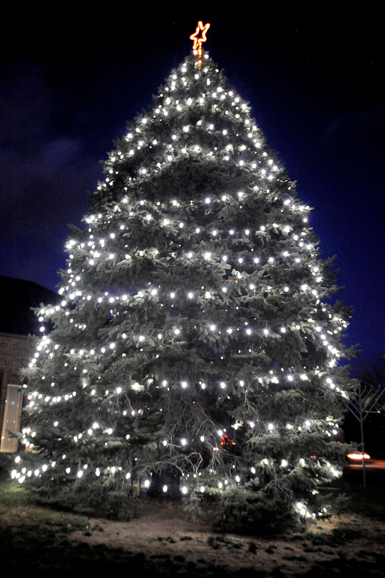 PETERSON AIR FORCE BASE, Colo. -- The Peterson Christmas tree near the base chapel was lit Dec. 7 as part of the monthly deployed family dinner. The crowd braved the cold and were treated to caroling, a visit from Santa, hot drinks and holiday cheer. (U.S. Air Force photo/Dennis Howk)