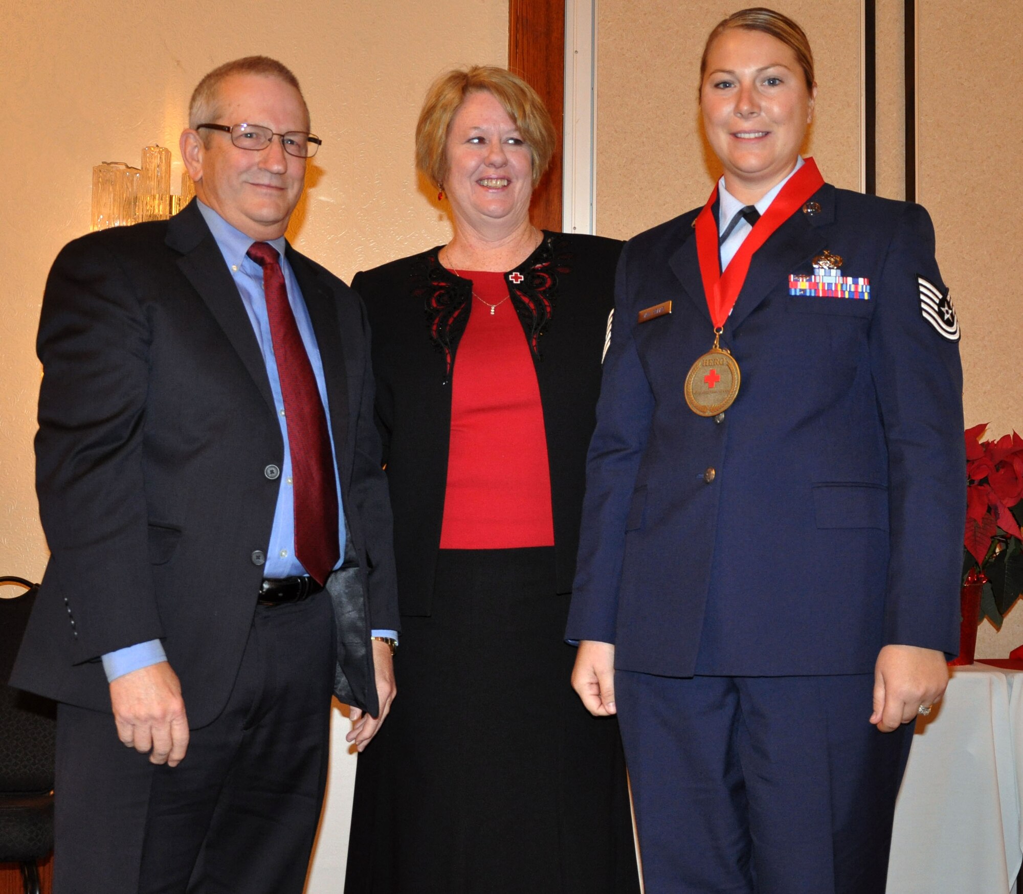 Bev Morlan, Regional Executive Director of the American Red Cross Midway-Kansas Chapter, and Jack Hall, vice-president of Capitol Federal Bank, present the Capitol Federal Red Cross Military Hero Award to Tech. Sgt. Carrie Van Praag, 931st Air Refueling Group Logistics Supply Manager, at the annual Wichita Heroes Breakfast, Dec. 12, 2012.  Van Praag accepted the award on behalf of her husband, 1st Lt. Craig Van Praag, who is currently deployed.  (U.S. Air Force photo by 1st Lt. Zach Anderson)