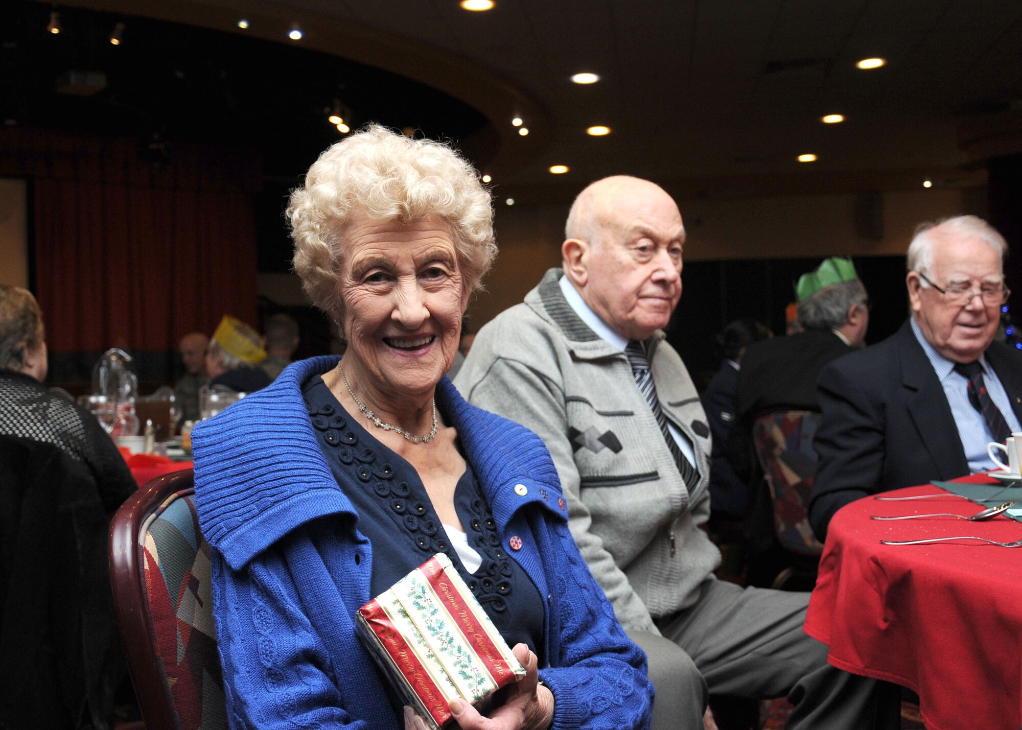 Joan Brewer, a guest at the 31st annual Senior Citizens Christmas party, wins a gift in the raffle Dec. 12, 2012, at RAF Mildenhall, England. The Top 3 hosted the party. (U.S. Air Force photo by Gina Randall/Released)