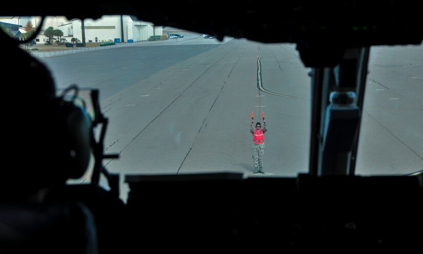 Capt. Brandon Dewey, 15th Airlift Squadron pilot, follows a crew chief’s instructions during an incentive flight Dec. 6, 2012, at Joint Base Charleston – Air Base. More than 50 quarterly award winners attended an incentive flight involving two C-17s which were conducting air drop training missions at JB Charleston’s – North Auxiliary Air Field. (U.S. Air Force photo/ Airman 1st Class Jared Trimarchi)