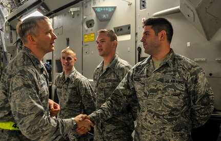 Col. Darren Hartford, 437th Airlift Wing commander, shakes hands with Airman Zachary Buzzell, 373rd Training Squadron crew chief student, during an incentive flight, Dec. 6, 2012, aboard a C-17 Globemaster III at Joint Base Charleston – Air Base.  More than 50 quarterly award winners attended the incentive flight onboard two C-17s which were conducting air drop training missions at Joint Base Charleston’s – North Auxiliary Air Field. (U.S. Air Force photo/ Airman 1st Class Jared Trimarchi)