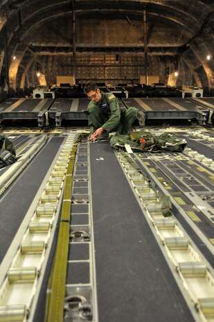 Senior Airman Josh Bischoff, 15th Airlift Squadron loadmaster, ties down a parachute prior to an incentive flight Dec. 6, 2012, aboard a C-17 Globemaster III at Joint Base Charleston – Air Base. More than 50 quarterly award winners attended the incentive flight onboard two C-17s, which were conducting air drop training missions at Joint Base Charleston’s – North Auxiliary Air Field. (U.S. Air Force photo/ Airman 1st Class Jared Trimarchi) 