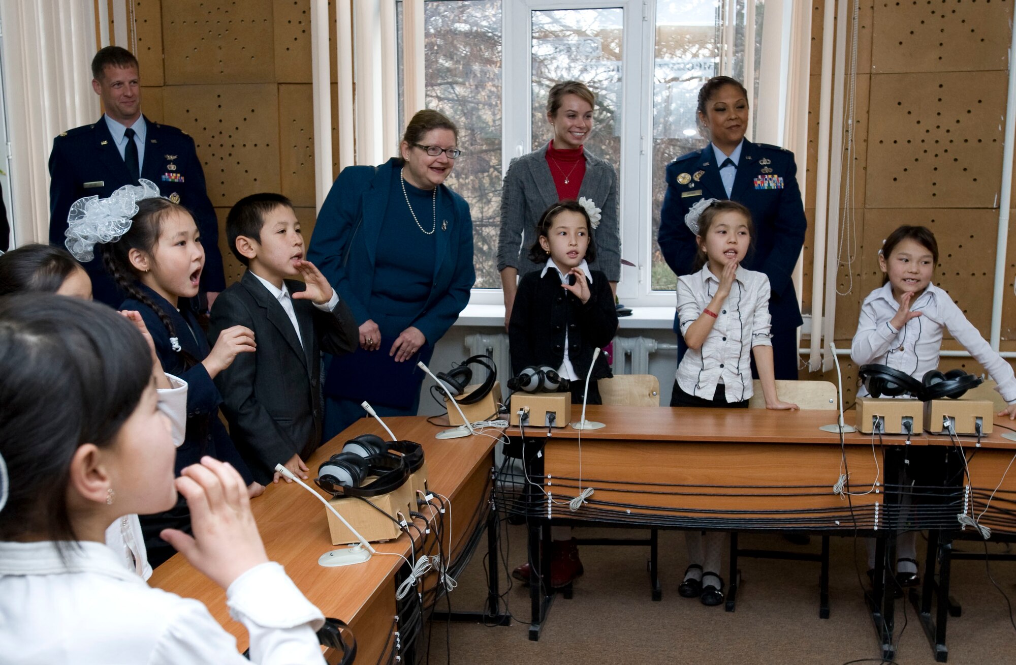 Transit Center at Manas distinguished guests and Laura Griesmer, U.S. Embassy Bishkek deputy chief of mission, visit with Bishkek School for the Deaf students prior to a dedication ceremony in Bishkek, Kyrgyzstan, Dec. 11, 2012. Students use sign language to communicate their appreciation for their newly renovated school. (U.S. Air Force photo / Staff Sgt. Stephanie Rubi)