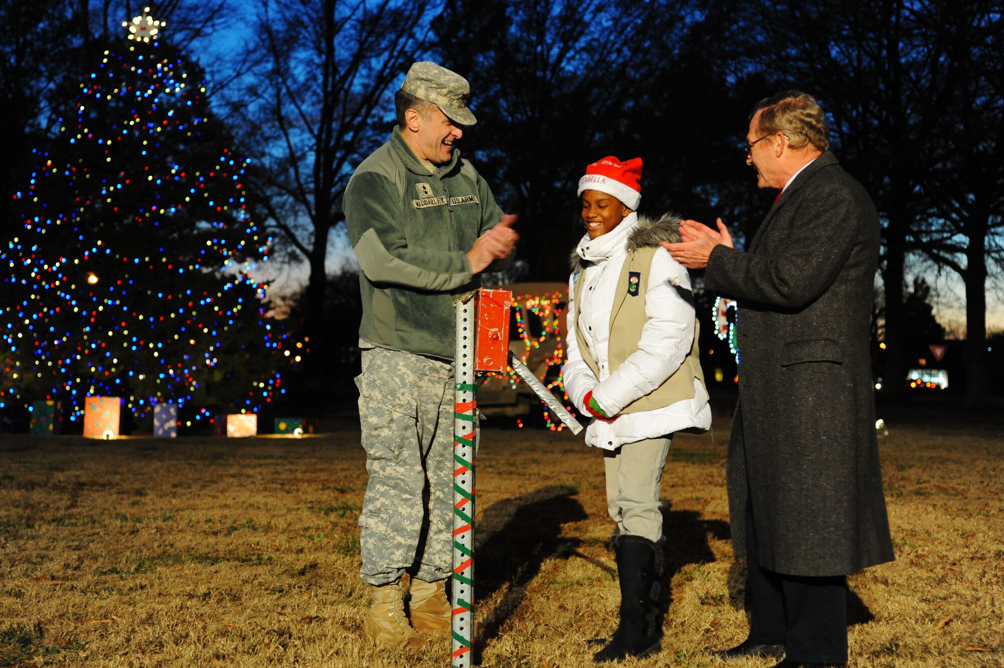 (From left) U.S. Army Maj. Gen. Mark MacCarley, U.S. Army Training and Doctrine Command deputy chief of staff of training, David K. Morrow, 733rd Mission Support Group deputy commander and 11-year-old Isabella Harvey, daughter of U.S. Army Spc. Norman Harvey, pull the lever to illuminate the Christmas tree during the annual Fort Eustis Christmas Tree Lighting celebration at Seay Plaza on Fort Eustis, Va., Dec. 6, 2012. Shortly after the tree lighting, Santa Claus and Mrs. Claus arrived aboard a Fort Eustis Fire Department ladder truck to greet children in the audience. (U.S. Air Force photo by Airman 1st Class Victoria Taylor/Released)