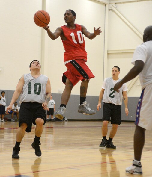 Kenneth Jones, 436th Maintenance Squadron guard, drives the lane and dishes off for a basket during the opening game of the intramural basketball season Dec. 10, 2012, at the Fitness Center on Dover Air Force Base, Del. Jones scored a team-high 16 points to help lead his team to a 37-30 victory against the 436th Security Forces Squadron. (U.S. Air Force photo by Tech. Sgt. Chuck Walker)