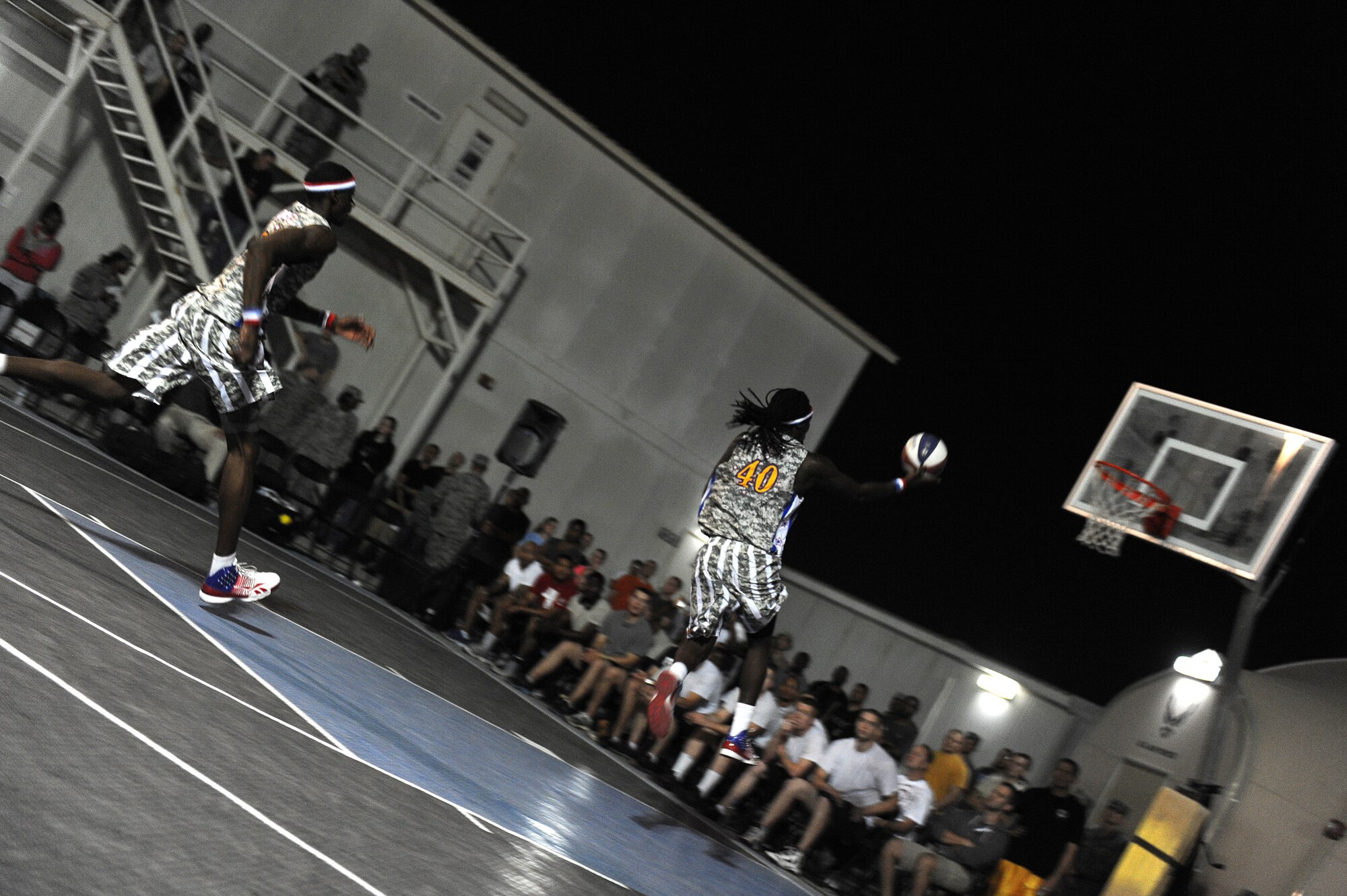 SOUTHWEST ASIA -- Harlem Globetrotter "Slick" Willie Shaw and "Bones" Millien perform at the 380th Air Expeditionary Wing during their 11th Holiday Military Tour Dec. 10, 2012. During this tour the Globetrotters debuted specially-designed camouflage uniforms and for the fourth year played a portion of the game with camouflage basketballs. (U.S. Air Force photo/Tech. Sgt. Christina M. Styer) (RELEASED)