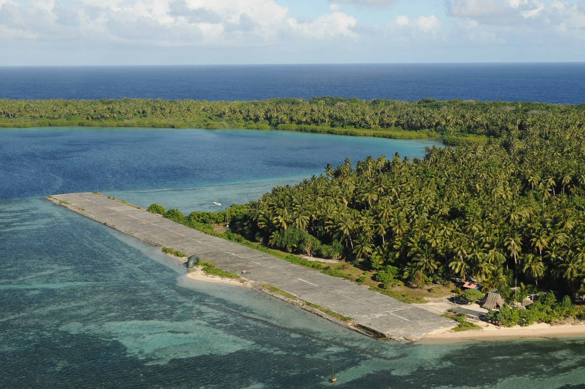 Two packages land on the runway at Pingelap Island, part of Pohnpei State of the Federated States of Micronesia, after a successful air drop during Operation Christmas Drop Dec. 12, 2012. Each year OCD provides aid to more than 30,000 islanders in Chuuk, Palau, Yap, Marshall Islands and Commonwealth of the Northern Mariana Islands. This year is the 61st anniversary of OCD, making it the longest running humanitarian mission in the world. In total, there are eight planned days of air drops, with 54 islands scheduled to receive humanitarian aid.  (U.S. Air Force photo by Senior Airman Carlin Leslie/Released)