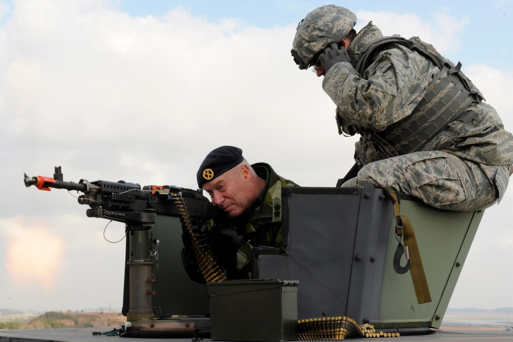 Staff Sgt. Troy Haugh, 8th Security Forces Squadron, shows Rear Admiral Anders Grenstad, head of Swedish Delegation to Neutral Nations Supervisory Commission, how to fire a .50 caliber machine gun on Kunsan Air Base, Republic of Korea, Nov. 18, 2012. The NNSC monitors both North and South Korea, investigates serious incidents and participates in any relative negotiations. (U.S. Air Force photo by Senior Airman Marcus Morris/released)
