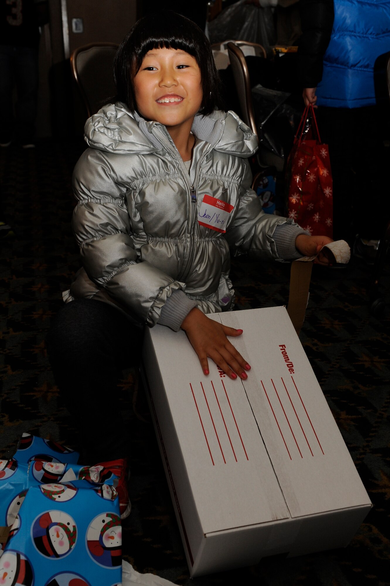 A child from Illmagwon Orphanage opens a present during a Christmas party at the Loring Club on Kunsan Air Base, Republic of Korea, Dec 1, 2012. The children also participated in many games and activities during the event including board games, coloring, musical chairs and watching Christmas movies. (U.S. Air Force photo by Marcus Morris/released)