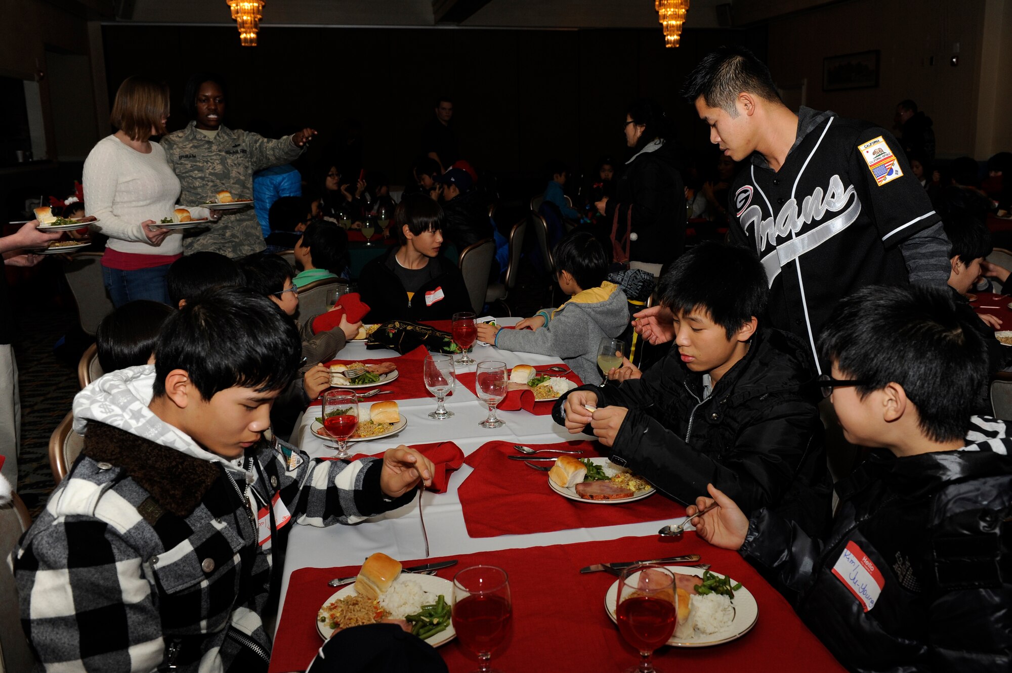 Volunteers from Kunsan Air Base, Republic of Korea, give children from Ilmagwon Orphanage a ham dinner to celebrate Christmas with them Dec, 1, 2012,. Bringing the orphanage onto base for Christmas has been an annual tradition and allows the volunteers to get gifts for the kids they spend time with. (U.S. Air Force photo by Senior Airman Marcus Morris/released)