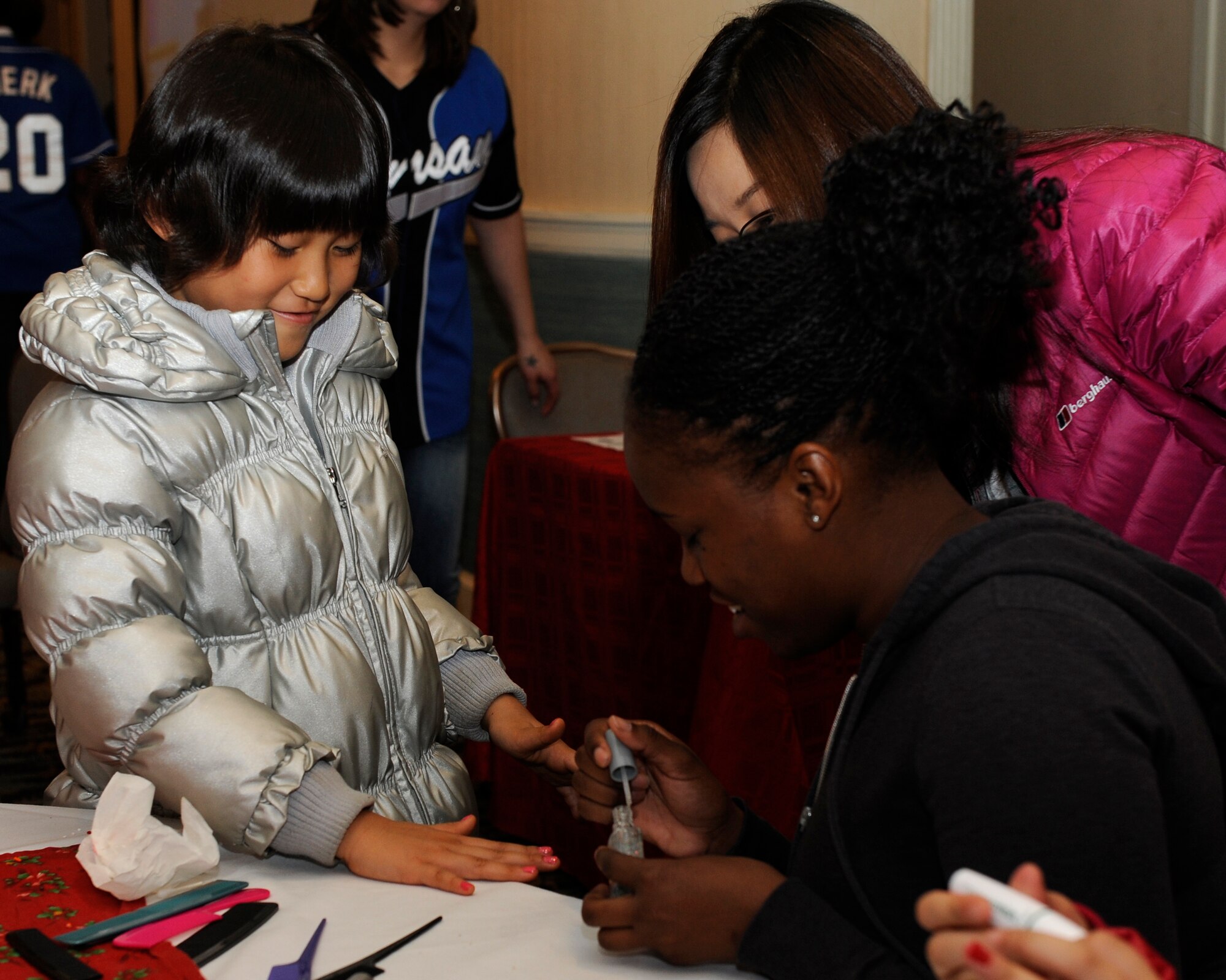 Senior Airman Jaynay Gonzalez, 8th Security Forces paints a girls nails during the Illmagwon Orphanage Christmas party at the Loring Club on Kunsan Air Base, Republic of Korea, Dec 1, 2012. More than 50 volunteers came out to spend time with the 74 children during the party. (U.S. Air Force photo by Senior Airman Marcus Morris/released)
