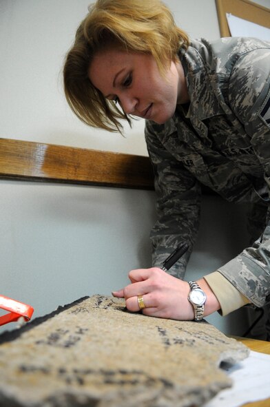 Master Sgt. Jennifer Wampler, outgoing 8th Operations Group first sergeant, signs a legacy piece of the Kunsan flightline during a round of goodbyes to her unit’s Airmen Dec. 11, 2012, at Kunsan Air Base, Republic of Korea. During her tour here, Wampler made it a priority to get to know her Airmen. (U.S. Air Force photo by Senior Airman Brigitte N. Brantley/Released)