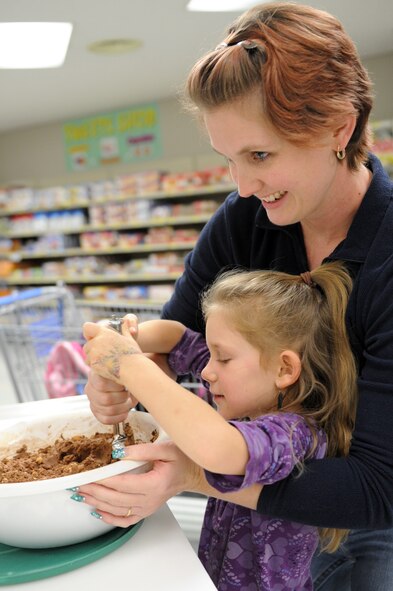 Jessica Caisse and her daughter scoop cookie dough into balls during the base’s annual Cookie Caper at Misawa Air Base, Japan, Dec. 10, 2012. Caisse and her daughter were Cookie Caper volunteers for Girl Scout Troop 46. Girl Scout Troop 46 made a total of 41 dozen cookies, which added to the base’s overall total of 31,800. (U.S. Air Force photo by Airman 1st Class Kia Atkins)