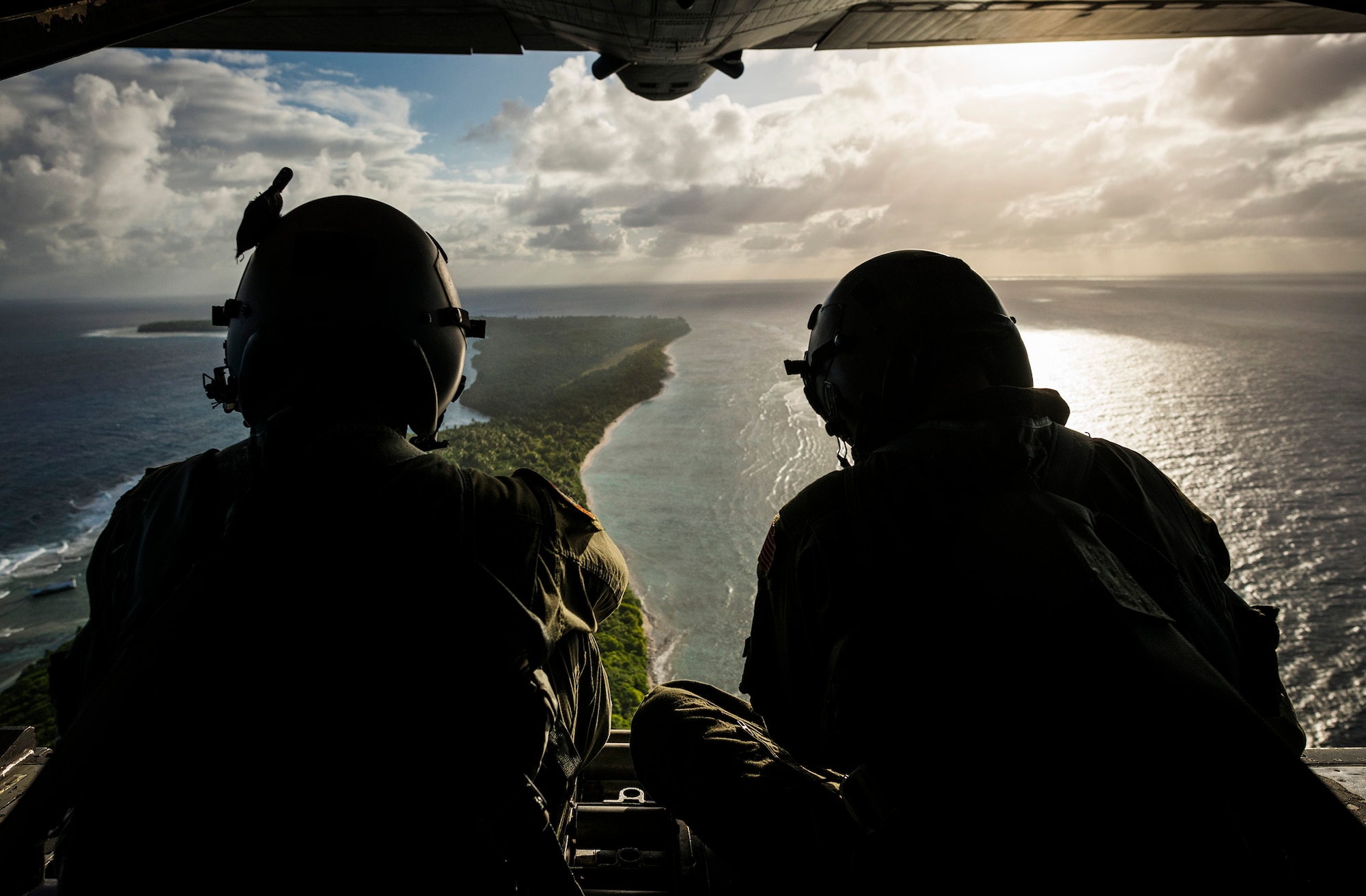 Senior Airman Timothy Oberman, left, and Staff Sgt. Nick Alarcon, loadmasters with the 36th Airlift Squadron, Yokota Air Base, Japan, watch out the back of a C-130H aircraft after dropping the first pallet of humanitarian goods to the island of Ulal Dec. 11, 2012.  Operation Christmas Drop is a non-profit organization powered by volunteers from Andersen Air Force Base and the local Guam community. Each year OCD provides aid to over 30,000 islanders in Chuuk, Palau, Yap, Marshall Islands and Commonwealth of the Northern Mariana Islands. This year is the 61st anniversary of OCD, making it the longest running humanitarian mission in the world. (U.S. Air Force photo by Tech. Sgt. Samuel Morse/Released)
