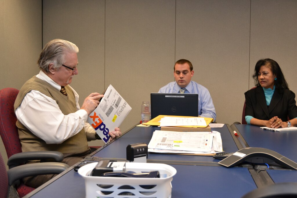 Chuck Hollingsworth, Ryan Shoemaker, and Maria Martin open and record sealed contractor bids at a public bid opening on Nov. 19, for the construction of facilities at Kandahar Airfield. 