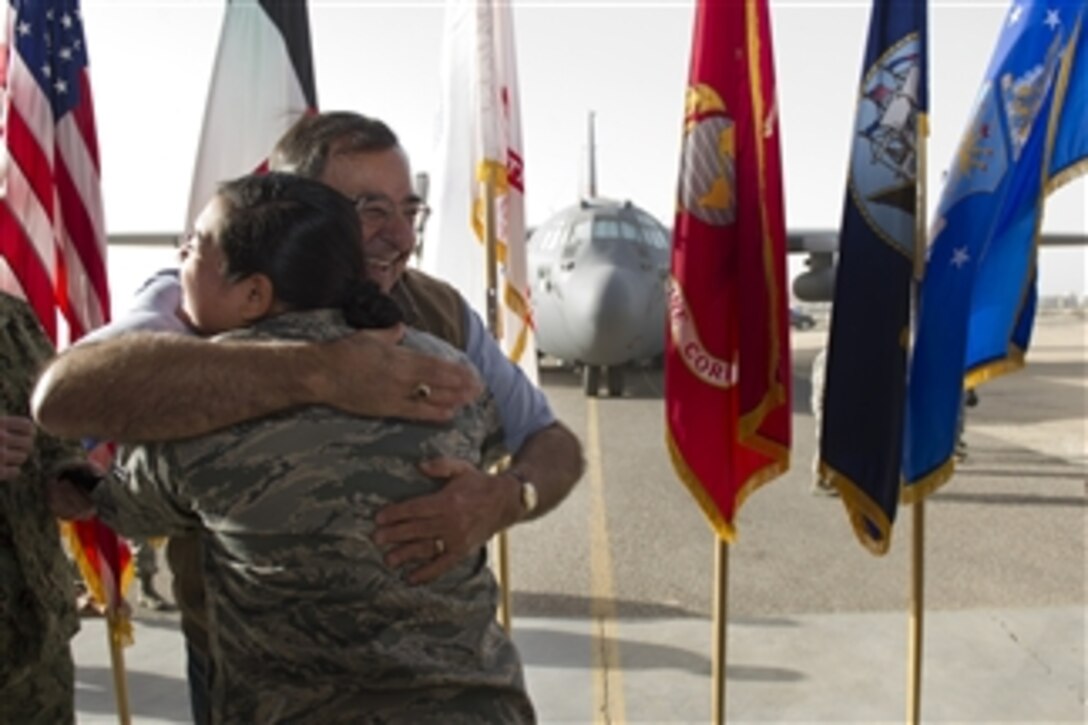 Secretary of Defense Leon E. Panetta hugs a nervous airman after she dropped the challenge coin Panetta presented her with at Ali Al Salem Air Base, Kuwait, on Dec. 12, 2012.  Panetta visited with the service members to wish them happy holidays and to thank them for their service.  Panetta is on a five-day trip to the region to meet with the troops and senior leadership.  