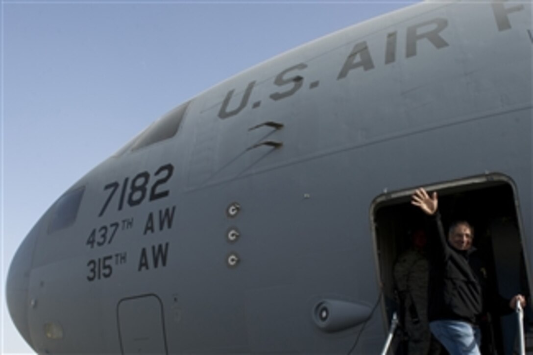 Secretary of Defense Leon E. Panetta waves goodbye to troops as he boards a C-17 Globemaster III at Ali Al Salem Air Base, Kuwait, on Dec. 12, 2012.  Panetta visited with the service members to wish them happy holidays and to thank them for their service.  Panetta is on a five-day trip to the region to meet with the troops and senior leadership