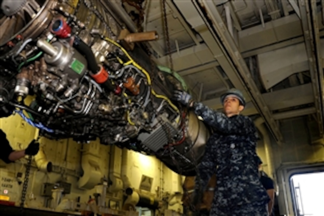 Navy Petty Officer 3rd Class Nick Evangelista hoists a F404-GE-404 engine aboard the aircraft carrier the USS Dwight D. Eisenhower the Atlantic Ocean, Dec. 10, 2012. The Dwight D. Eisenhower is returning to Norfolk after operating in the U.S. 5th and 6th Fleet areas of responsibility in support of Operation Enduring Freedom, maritime security operations and theater security cooperation efforts. 