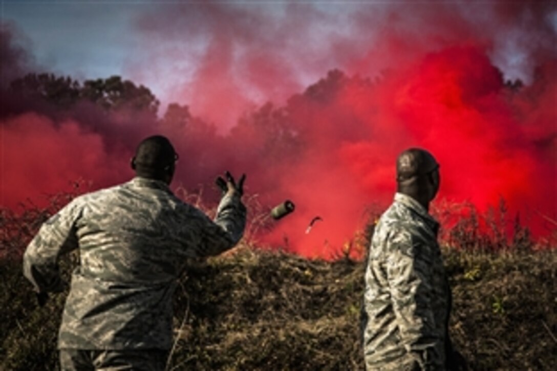 Air Force Staff Sgt. Brandon Washington, right, observes Air Force Tech. Sgt. Rudolph Stuart throw a smoke grenade during combat readiness training with the 628th Explosive Ordnance Squadron at Joint Base Charleston, S.C., Nov. 30, 2012. Airmen attended an hour-long class to review safety procedures when handling grenades. 