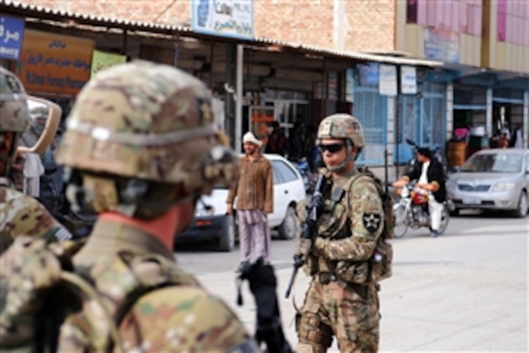 U.S. Army Spc. Giovanni Gonzalez, right, provides security outside a meeting in Farah City, Afghanistan, Dec. 5, 2012. Gonzalez is assigned to Provincial Reconstruction Team Farah.