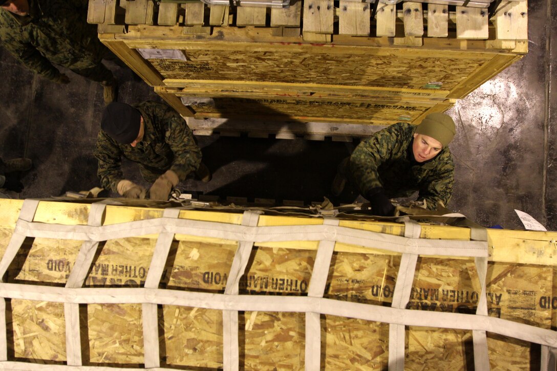 TRONDHEIM, Norway- Staff Sergeant Joseph Conradi, embark specialist, Marine Forces, Europe  and MSgt. Steven Albanese, facilities chief, Marine Forces, Europe secure the cargo straps on a pallet, while assembling a shipment of sustainment equipment headed to the Republic of Georgia to support the Georgia Deployment Program. During the course of three days a team of five Marines from Marine Forces, Europe, II Marine Expeditionary Force and two airmen from the 819th Red Horse Squadron  assembled 14 pallets of gear, set to be delivered to training areas in the Republic of Georgia.  The shipment contained tents, a shower system, tool kits, generators, fuel bladders and host of other items, intended to help the Marines and their Georgian counterparts, to enhance the living conditions in training areas in the Republic of Georgia. 