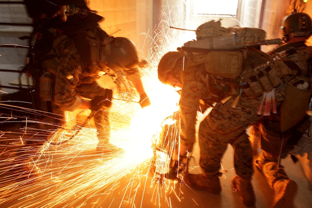 Marines with the Maritime Raid Force, 31st Marine Expeditionary Unit, use a circular saw to ignite a Brocos torch while attempting to breach steel barricades, July 9. The raid was part of the Realistic Urban Training Exercise, evaluated by Special Operations Training Group. It is designed to integrate unique individual and small unit skills in conjunction with the 31st MEU's increased proficiency in the rapid response planning process in a challenging and unfamiliar environment. The 31st MEU is the United States' force in readiness for the Asia Pacific.