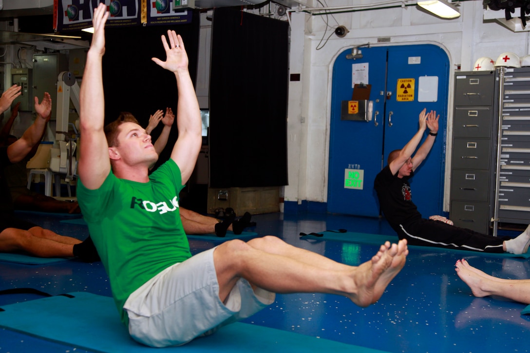 Capt. Matt T. Davis, AH-1Z pilot, Marine Medium Helicopter Squadron 364 (Rein.), 15th Marine Expeditionary Unit, performs a Pilates exercise during a PITAIYO class in the medical facility aboard the USS Peleliu, Dec. 7. PITAIYO, an acronym for put it together all in your orbit, is a fusion of Pilates, Tai-chi, and yoga blended into one class. It is designed to increase core strength, flexibility, balance and coordination. The class is another opportunity Marines and sailors have to allow their minds to decompress from the stresses of deployment. The 15th MEU is deployed as part of the Peleliu Amphibious Ready Group as a U.S. Central Command theater reserve force, providing support for maritime security operations and theater security cooperation efforts in the U.S. 5th Fleet area of responsibility. Davis, 26, is from Viera, Fla. (U.S. Marine Corps photo by Cpl. John Robbart III)