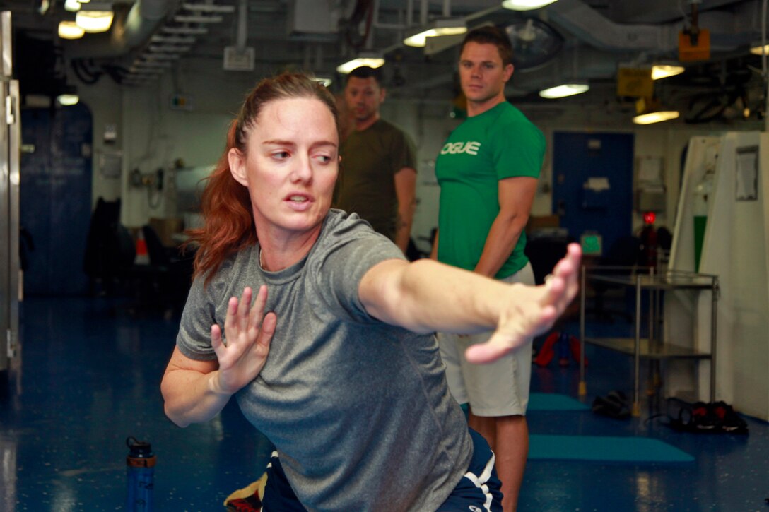 Gunnery Sgt. Jennifer M. Antoine, PITAIYO instructor and the public affairs chief, 15th Marine Expeditionary Unit, teaches movements during a PITAIYO class in the medical facility aboard the USS Peleliu, Dec. 7. PITAIYO, an acronym for put it together all in your orbit, is a fusion of Pilates, Tai-chi, and yoga blended into one class. It is designed to increase core strength, flexibility, balance and coordination. The class is another opportunity Marines and sailors have to allow their minds to decompress from the stresses of deployment. The 15th MEU is deployed as part of the Peleliu Amphibious Ready Group as a U.S. Central Command theater reserve force, providing support for maritime security operations and theater security cooperation efforts in the U.S. 5th Fleet area of responsibility. Antoine, 39, is from Altoona, Wis. (U.S. Marine Corps photo by Cpl. John Robbart III)