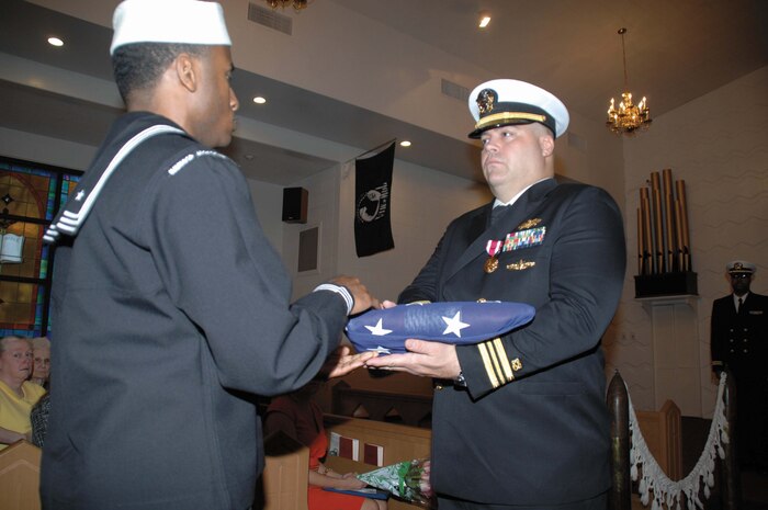 Lt. Cmdr. Jeffrey L. Benjamin, public works officer and resident officer-in-charge of construction, Installation and Environmental Division, Marine Corps Logistics Base Albany, is presented numerous awards and letters of recognition during his retirement ceremony, Friday.  The retirement ceremony was held in the Base Chapel. 
