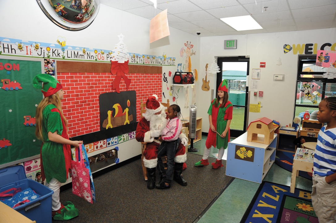 A child tells Santa her Christmas wishes during Santa’s Village, hosted by Child Development Center staff at Building 5500, Dec. 8. The event featured games, crafts, refreshments and photographs with Santa.